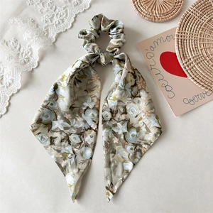 Detailansicht eines Haargummis mit Blumenmuster und langen Bändern in Vintage-Salbei