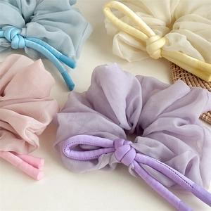 Chiffon scrunchies set in blue, yellow, pink, and purple with knot details shown on desk