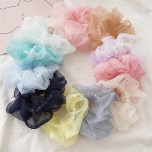 Gros plan de chouchous en organza avec perles blanches en plusieurs couleurs pastel