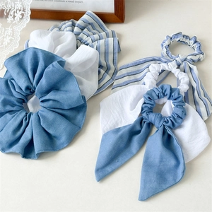 Close-up of blue striped scrunchies and bow hair ties set with soft fabric texture