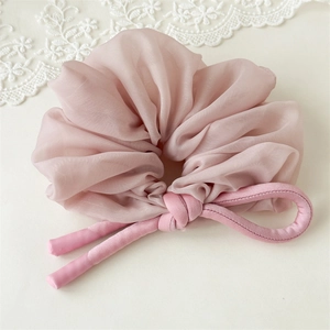 Detail view of pink sheer organza scrunchie with long ribbon ties and elegant soft folds