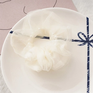 Vue détaillée d'un chouchou en organza blanc orné de perles d'imitation élégantes