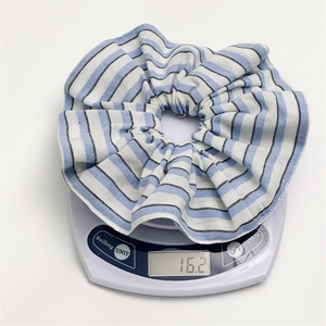 Blue and white striped scrunchie hair tie weighing 16.2g on a scale display