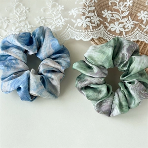 Detail of artistic oil painting marble pattern satin scrunchies set on lace decor