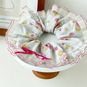 Chouchou fleuri rose avec dentelle et nœud fuchsia pour coiffures chignons