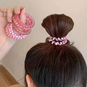 Spiral elastic hair ties set in sea salt blue and pink colors shown in use for high ponytail
