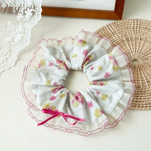 Détail de chouchou floral rose avec dentelle et ruban sur fond de dentelle blanche