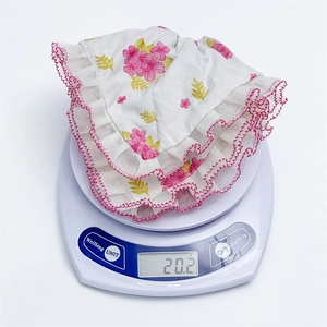 Chouchou en dentelle à fleurs roses avec nœud affichant 20,2g sur une balance électronique