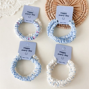 Détail du lot de chouchous bleus à carreaux et pois avec motifs étoiles sur carton