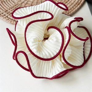 Close-up of pleated chiffon hair scrunchie with ruffled edges and contrast stitching