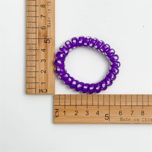 Detailed scale measurement of purple spiral hair tie with white polka dots