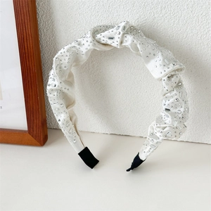 Detail of cream pleated satin headband with sparkling silver rhinestones and end protectors