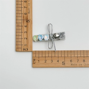Barrette argentée à paillettes avec trois strass colorés et un petit pendentif cœur