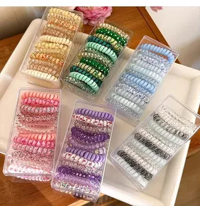 Detail view of multi-color spiral hair ties sets organized in six clear plastic boxes