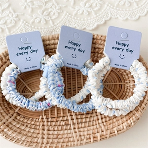 Lot de chouchous en tissu à carreaux bleus et pois dans un plateau décoratif en osier