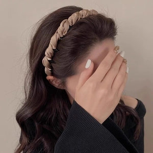 Close-up of champagne gold braided headband with non-slip black inner comb detail