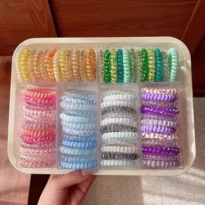Macro shot of colorful spiral hair ties in a transparent six-grid storage box organizer