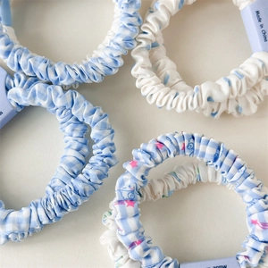 Vue détaillée des chouchous en coton à carreaux et pois bleus et blancs avec étiquettes