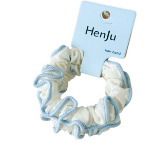 Chouchou floral blanc et bleu clair avec bord volanté et carte de présentation