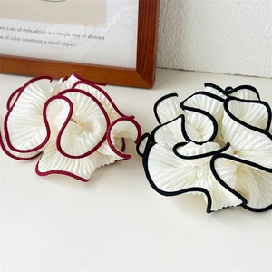 Detail showing two tiered ruffle hair scrunchies with elegant red and black contrast piping