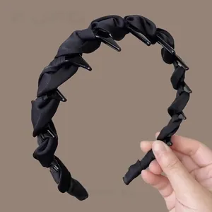 Detail showing cross-woven black satin headband texture with non-slip inner teeth design