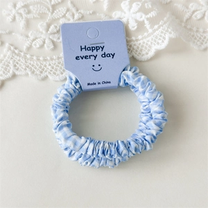 Vue détaillée du chouchou à carreaux bleus sur une carte Happy Every Day et dentelle