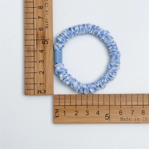 Chouchou à carreaux bleus avec échelle de mesure indiquant un diamètre de 5,5 cm