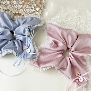 Blue and pink satin scrunchies with white lace edges, buttons, and ribbon bow details