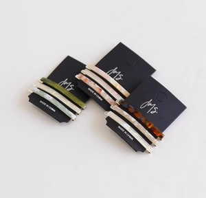 Detail showing high-end acetate hair clips with marble patterns on black display cards