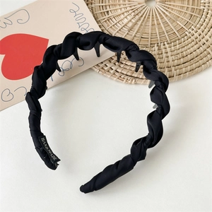 Detail showing inner anti-slip comb teeth and handmade label on black fabric headband