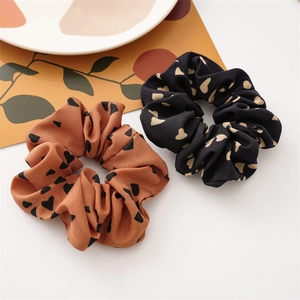 Vista dettagliata di elastici per capelli in raso con cuori nero e caramello