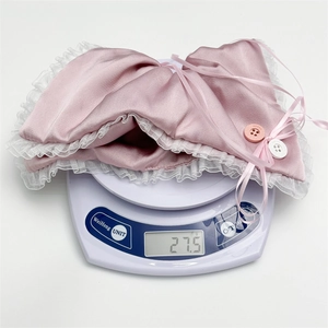 Pink satin scrunchie with lace trim and bow, shown on scale weighing 27.5g