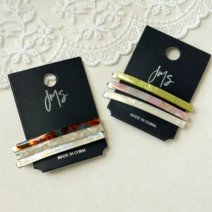 Close-up of three-piece acetate hair clip sets on card, marble and tortoiseshell patterns