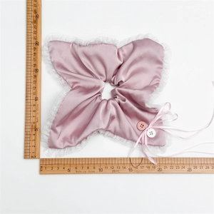 Close-up of pink satin scrunchie with lace edges and buttons showing 20cm size