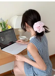 Detailed back view of a woman wearing a pink pleated oversized scrunchie for a ponytail