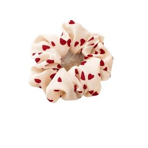 Elastico per capelli color crema con cuori rossi su supporto decorativo