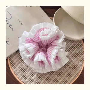 Detail of pink striped layered scrunchie with floral ruffles and French vintage style