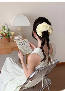 Detailed view of creamy beige oversized scrunchie worn on a French style ponytail