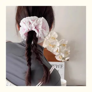 Rear view of a pink striped oversized scrunchie on a braided ponytail style