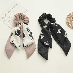 Set of two polyester scrunchies with floral ribbons in pink and black colors