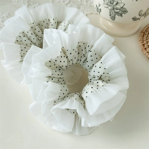 Detail of double-layer white lace and black polka dot scrunchie fabric and texture