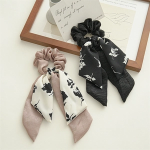 Detail view of double-layer floral ribbon scrunchies with soft satin texture for ponytails