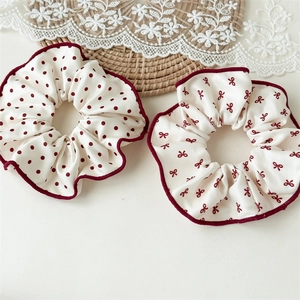 Détail de chouchous à pois rouges et nœuds sur dentelle élégante et tapis en paille
