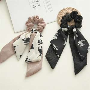 Close-up of double layer bow scrunchies with floral ribbons in rose and black chiffon