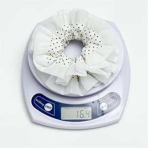 Black and white polka dot chiffon scrunchie weighing 16.4g on a digital scale