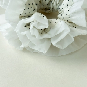 Macro shot of double-layered black and white polka dot scrunchie with lace trimming
