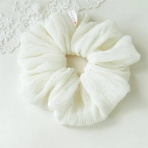Close-up of off-white pleated bubble hair scrunchie with handmade heart label
