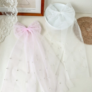 Détail de nœud de cheveux en tulle avec perles blanches et longs rubans roses et blancs