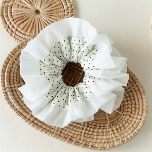 Close-up of double-layer white lace hair tie with black polka dots and chiffon texture