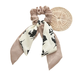 Elegant mauve polyester ribbon scrunchie with floral bow on a clean white background